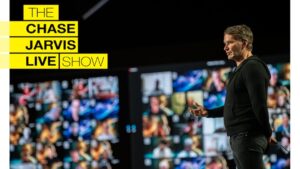 Keith Ferrazzi speaking on stage in front of a large, vibrant screen displaying multiple video call participants, with 'The Chase Jarvis Live Show' logo in bold yellow and black text on the left.